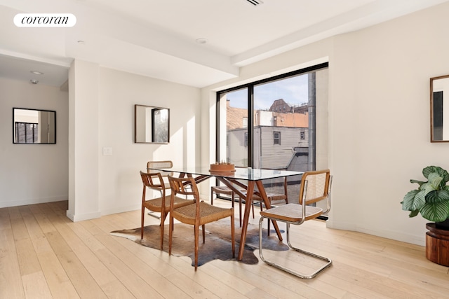 dining space with light wood-style floors, baseboards, and visible vents