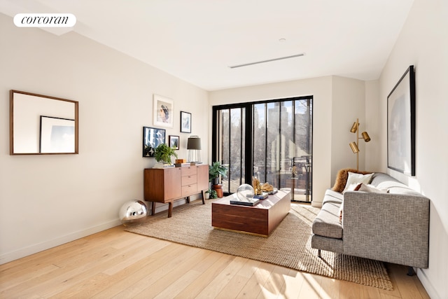 living area with wood-type flooring and baseboards