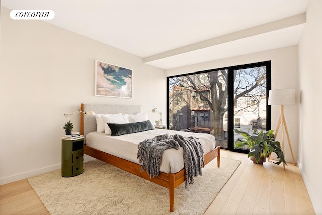 bedroom with baseboards and wood finished floors