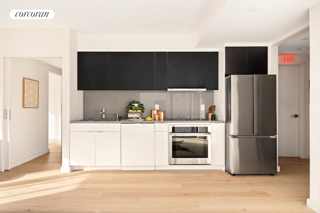 kitchen with stainless steel appliances, light wood-style floors, visible vents, and white cabinetry