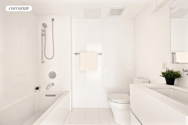 full bath with tile walls, tile patterned floors, shower / bath combination, toilet, and vanity