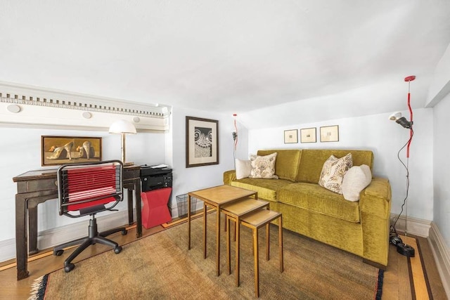 living room with lofted ceiling, baseboards, and wood finished floors