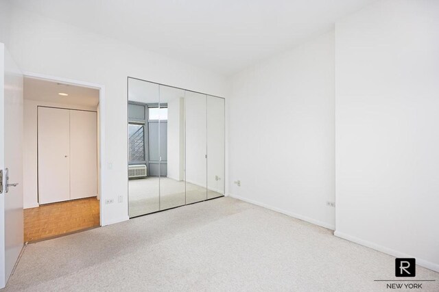 unfurnished bedroom featuring light colored carpet and baseboards