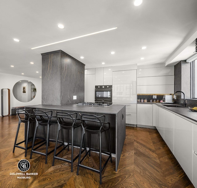 190 E 72nd St Unit 31B, New York City, NY 10021 - kitchen featuring modern cabinets, oven, dark countertops, a kitchen breakfast bar, and tasteful backsplash