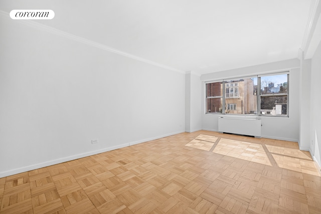 spare room featuring visible vents, radiator heating unit, baseboards, and ornamental molding