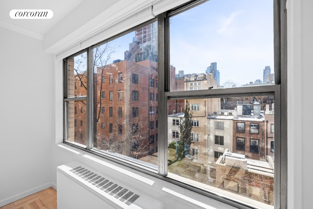 room details featuring a view of city, baseboards, visible vents, and ornamental molding