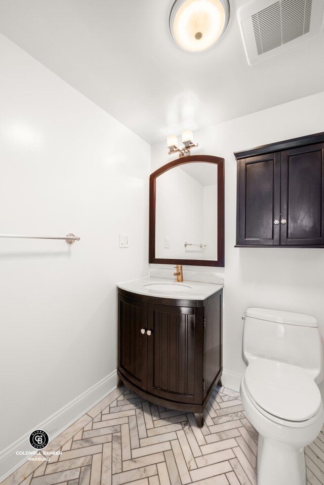 bathroom with toilet, baseboards, visible vents, and vanity