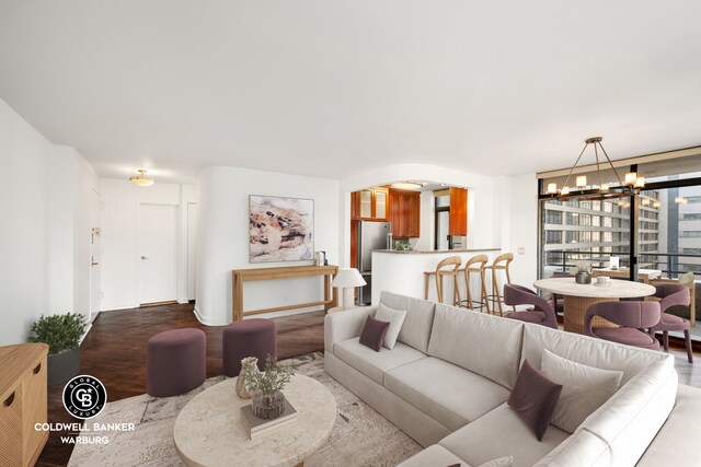 unfurnished living room with a chandelier, radiator, and baseboards