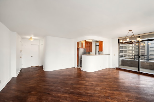 400 E 70th St Unit 1001, New York City, NY 10021 - unfurnished living room with a chandelier, dark wood finished floors, and arched walkways