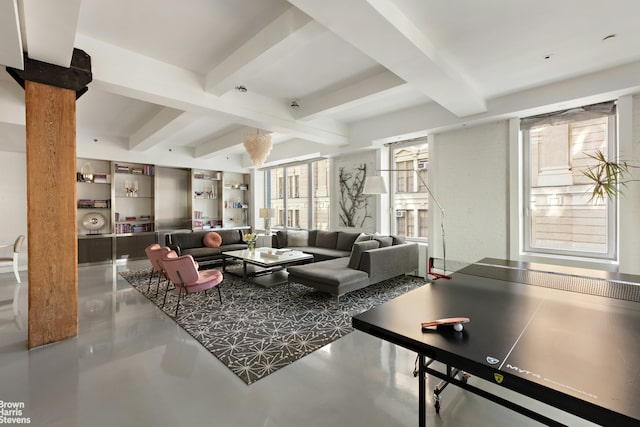 living area with beamed ceiling and concrete floors