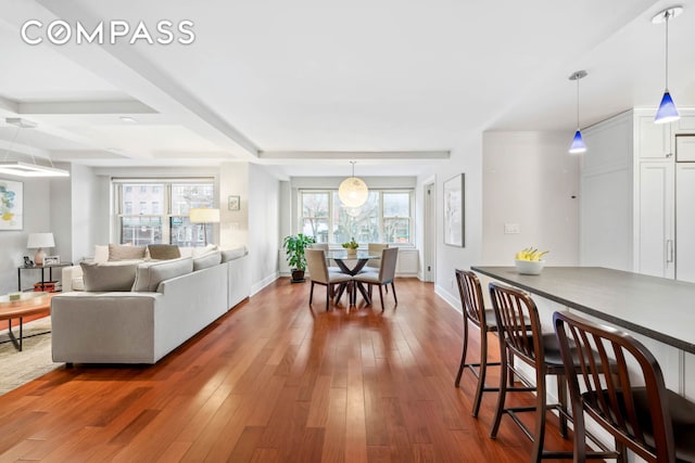 dining room with baseboards, hardwood / wood-style flooring, and a healthy amount of sunlight