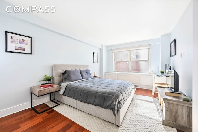 bedroom with wood finished floors and baseboards