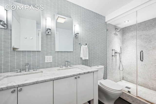 bathroom featuring a stall shower, a sink, and tile walls