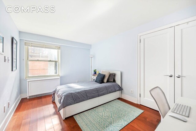 bedroom with dark wood finished floors and baseboards