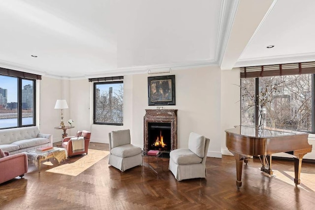 living room featuring baseboards, crown molding, and a high end fireplace