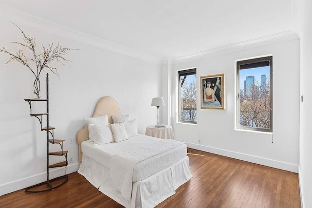 bedroom featuring ornamental molding, dark wood finished floors, and baseboards