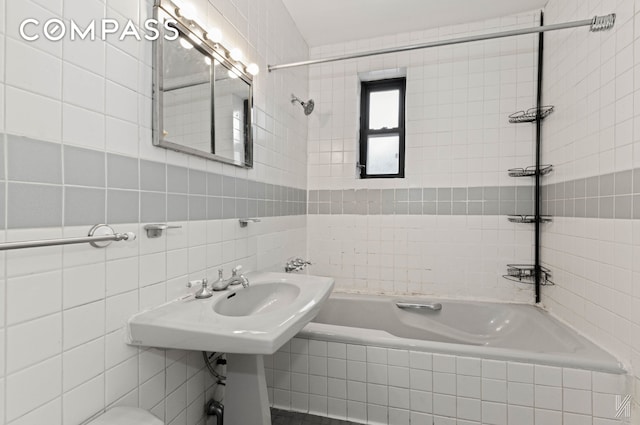 bathroom with tiled shower / bath and tile walls