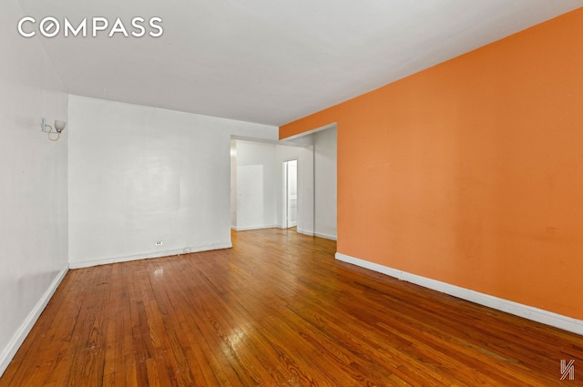 spare room with hardwood / wood-style flooring and baseboards