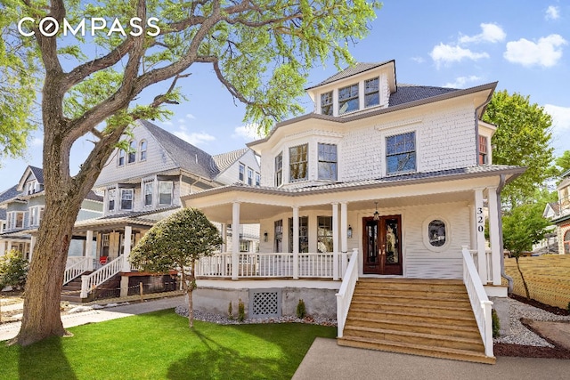 traditional style home featuring covered porch, a front yard, and stairs