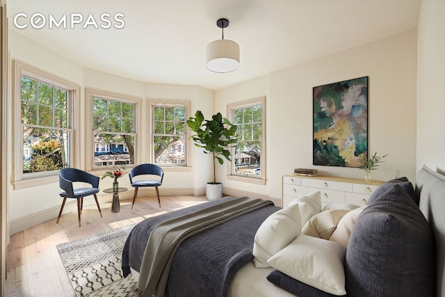 bedroom featuring light wood-style floors and baseboards