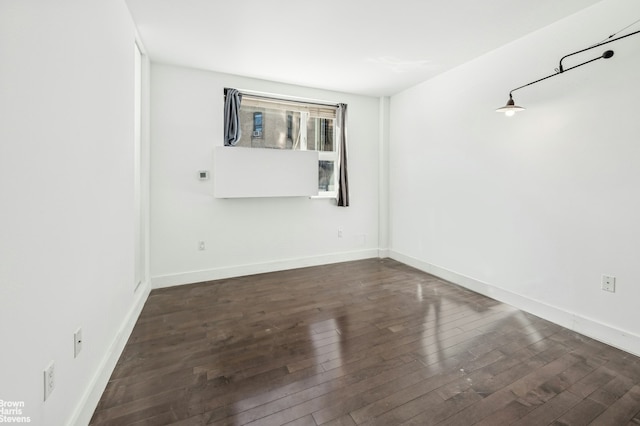 unfurnished room featuring baseboards and wood-type flooring