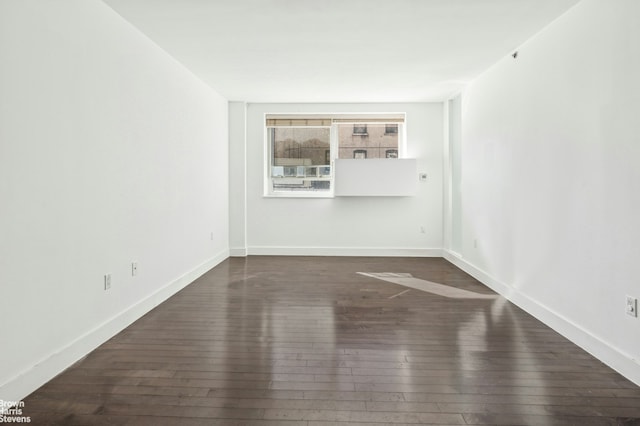 unfurnished room featuring baseboards and wood-type flooring