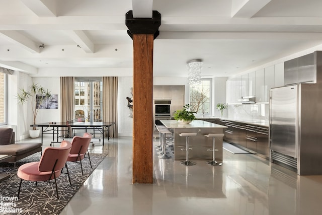 kitchen with light countertops, white cabinetry, a kitchen island, modern cabinets, and beamed ceiling