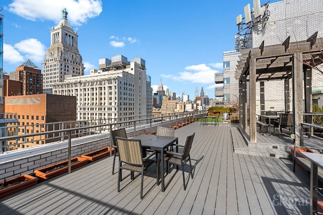 deck featuring a view of city, outdoor dining area, and a pergola