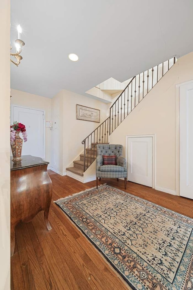 foyer entrance with stairs, recessed lighting, wood finished floors, and baseboards