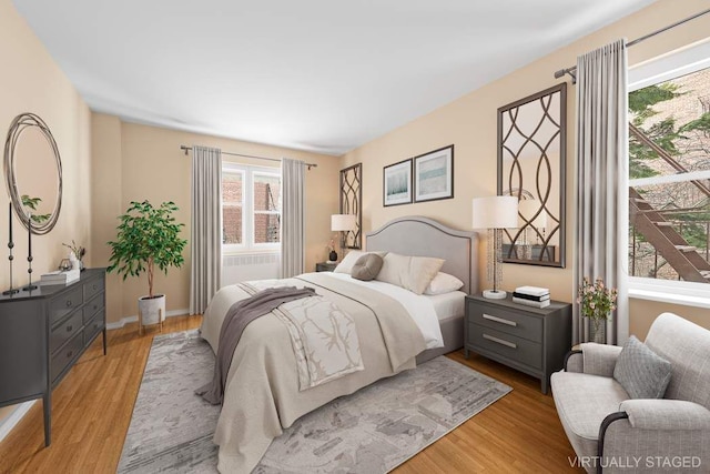 bedroom featuring baseboards and light wood finished floors