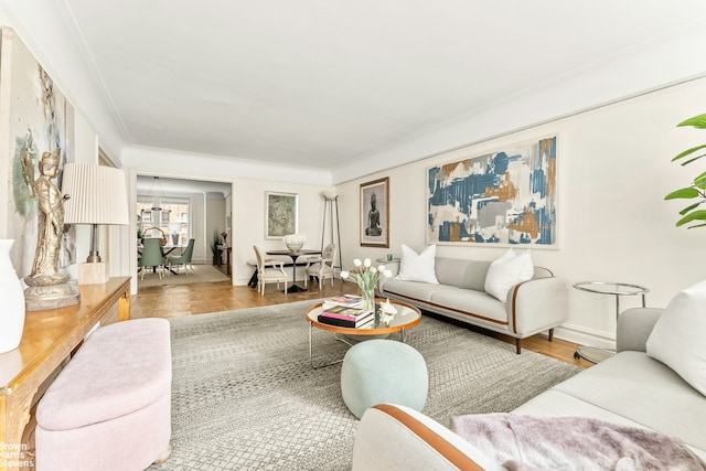 living area with baseboards, ornamental molding, and wood finished floors