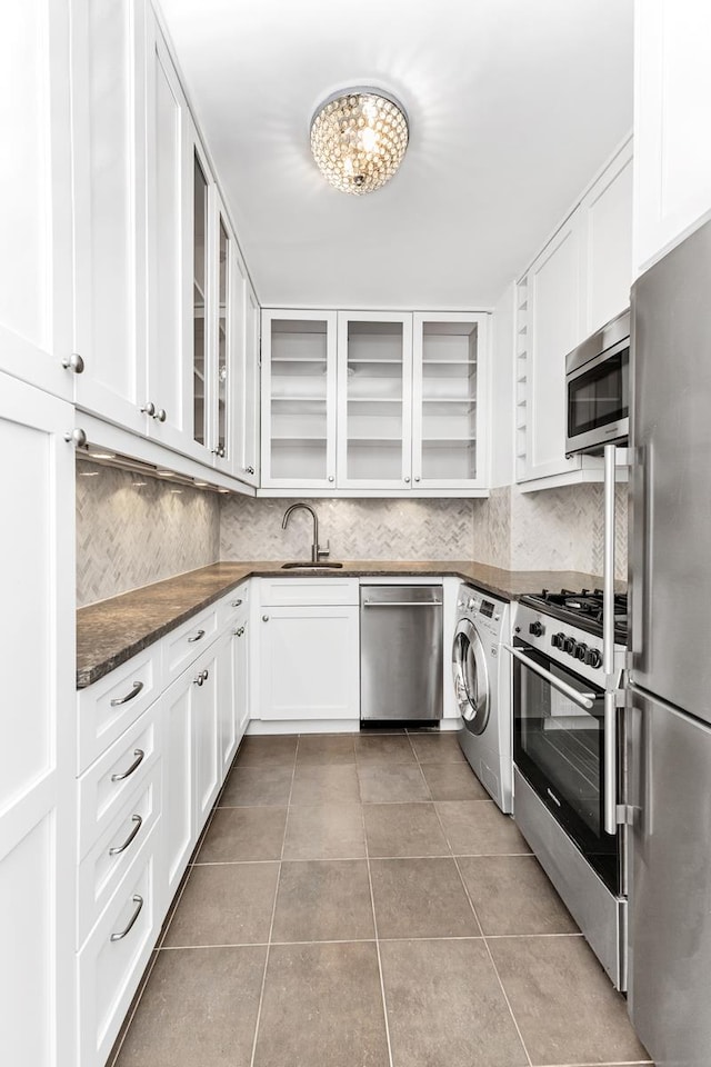 kitchen with light tile patterned floors, washer / clothes dryer, appliances with stainless steel finishes, glass insert cabinets, and white cabinets