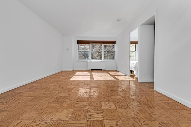 unfurnished room with radiator and baseboards