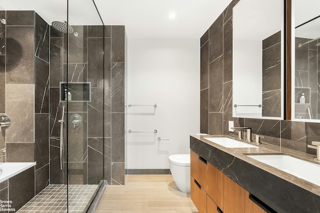 full bathroom featuring toilet, backsplash, a tile shower, and a sink