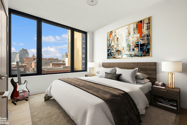 bedroom featuring wood finished floors and a city view