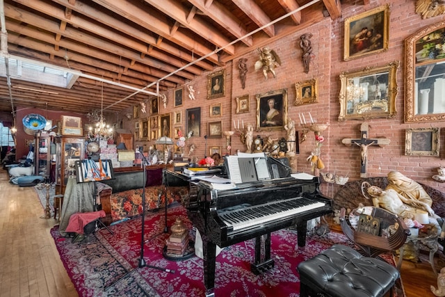 miscellaneous room with wood-type flooring and brick wall