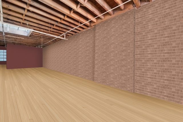 below grade area featuring brick wall and wood finished floors