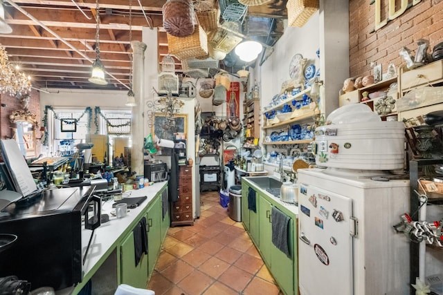 kitchen with brick wall, light tile patterned flooring, and green cabinets