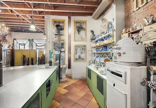 kitchen with green cabinets, brick wall, light tile patterned floors, and light countertops