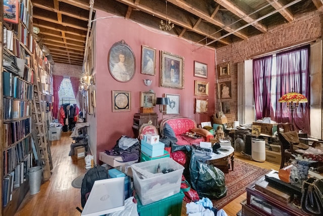 miscellaneous room featuring brick wall and wood finished floors