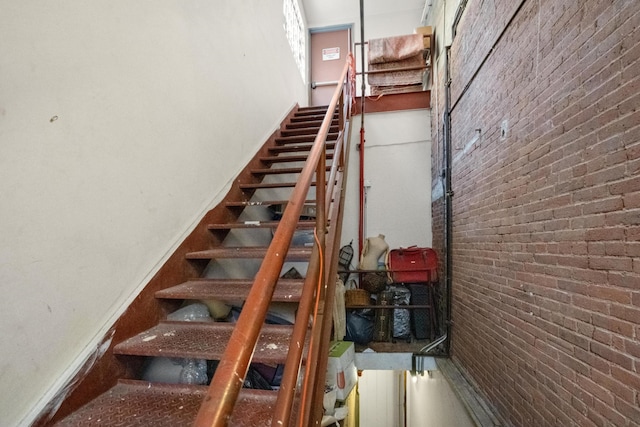 stairs with a high ceiling and brick wall