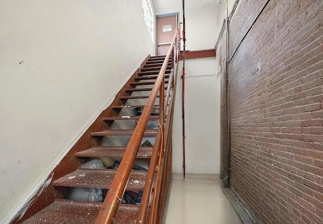 stairs with brick wall and a high ceiling