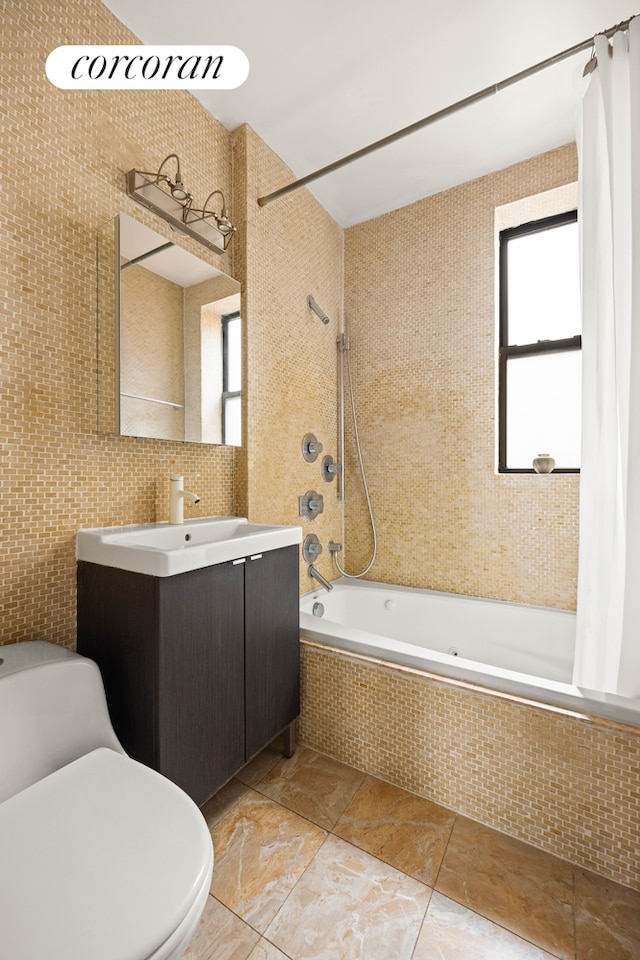 full bathroom with tile walls, tasteful backsplash, toilet, tiled shower / bath combo, and vanity