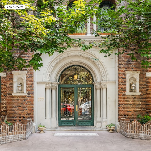 entrance to property featuring french doors and brick siding