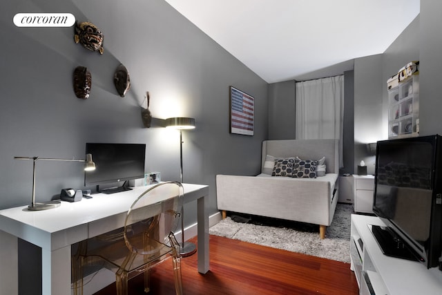 bedroom with vaulted ceiling, wood finished floors, visible vents, and baseboards