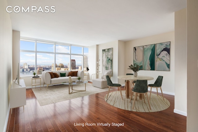 dining room featuring a view of city, baseboards, and wood finished floors