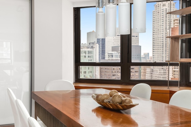 dining room featuring a healthy amount of sunlight and a city view