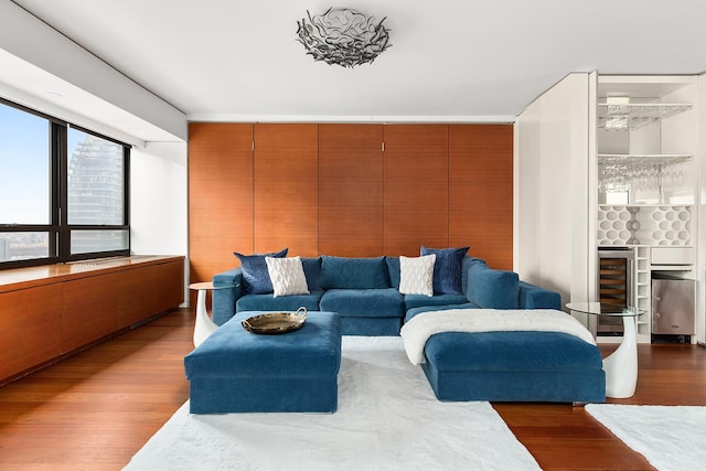 living area with wine cooler, wood finished floors, and a dry bar