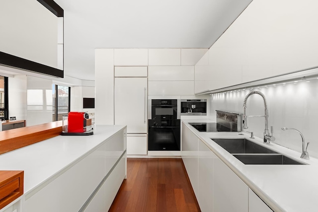 kitchen featuring a sink, modern cabinets, white cabinets, dark wood-style floors, and light countertops