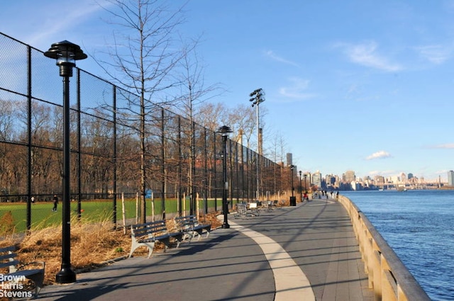 view of home's community featuring a water view and fence